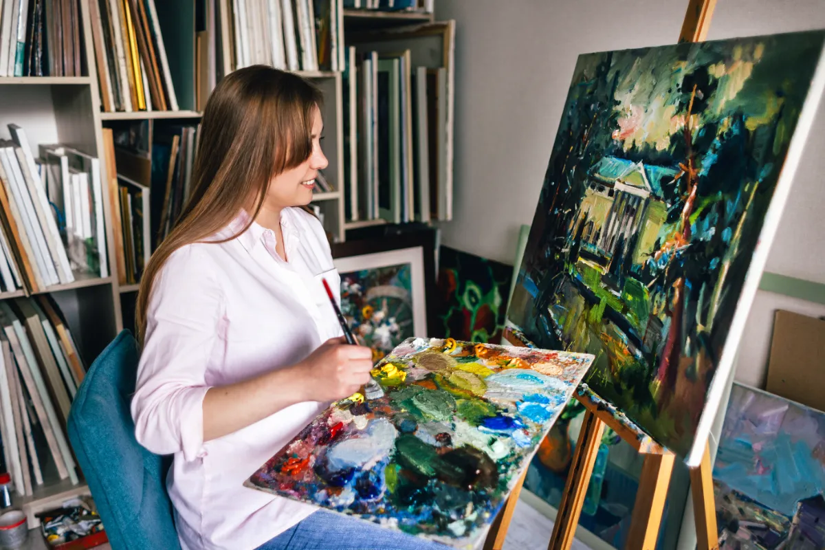 female paints picture with oil paints