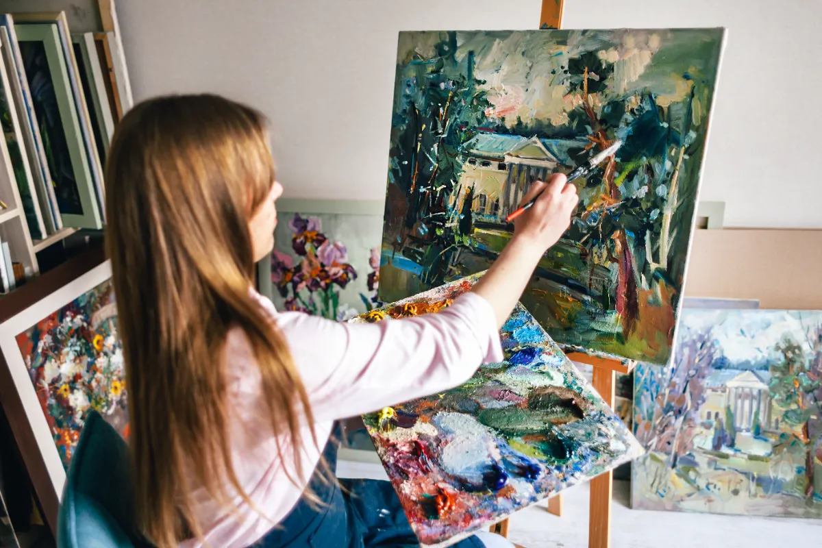 girl paints oil painting of house