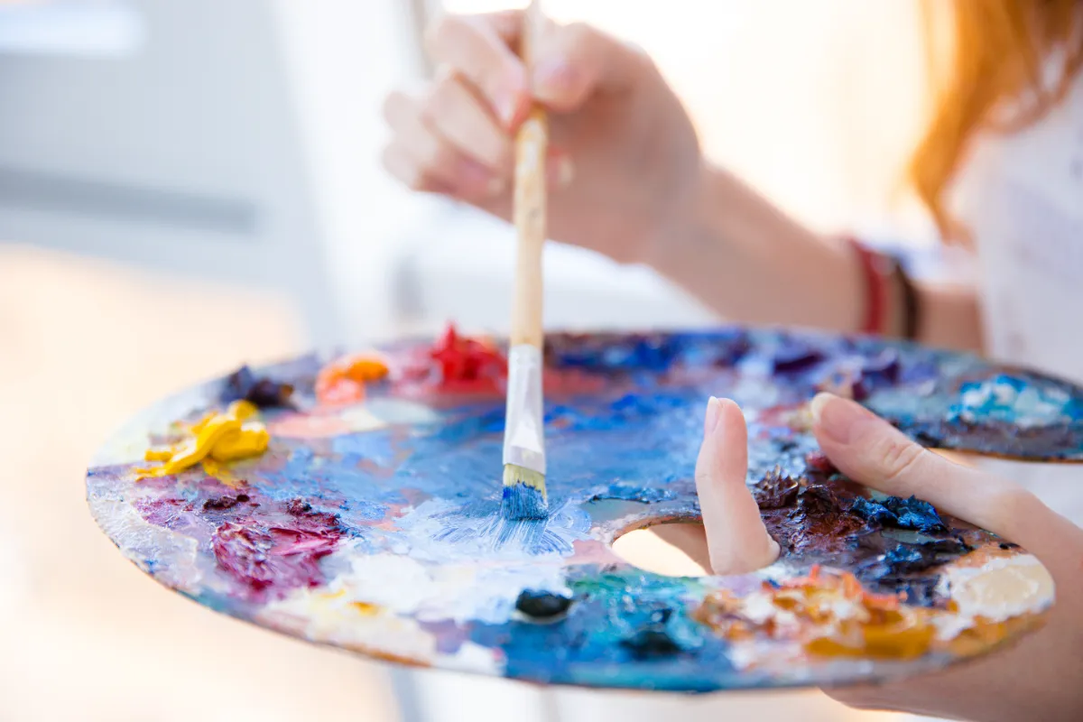 paintbrush in hands mixing oil paints