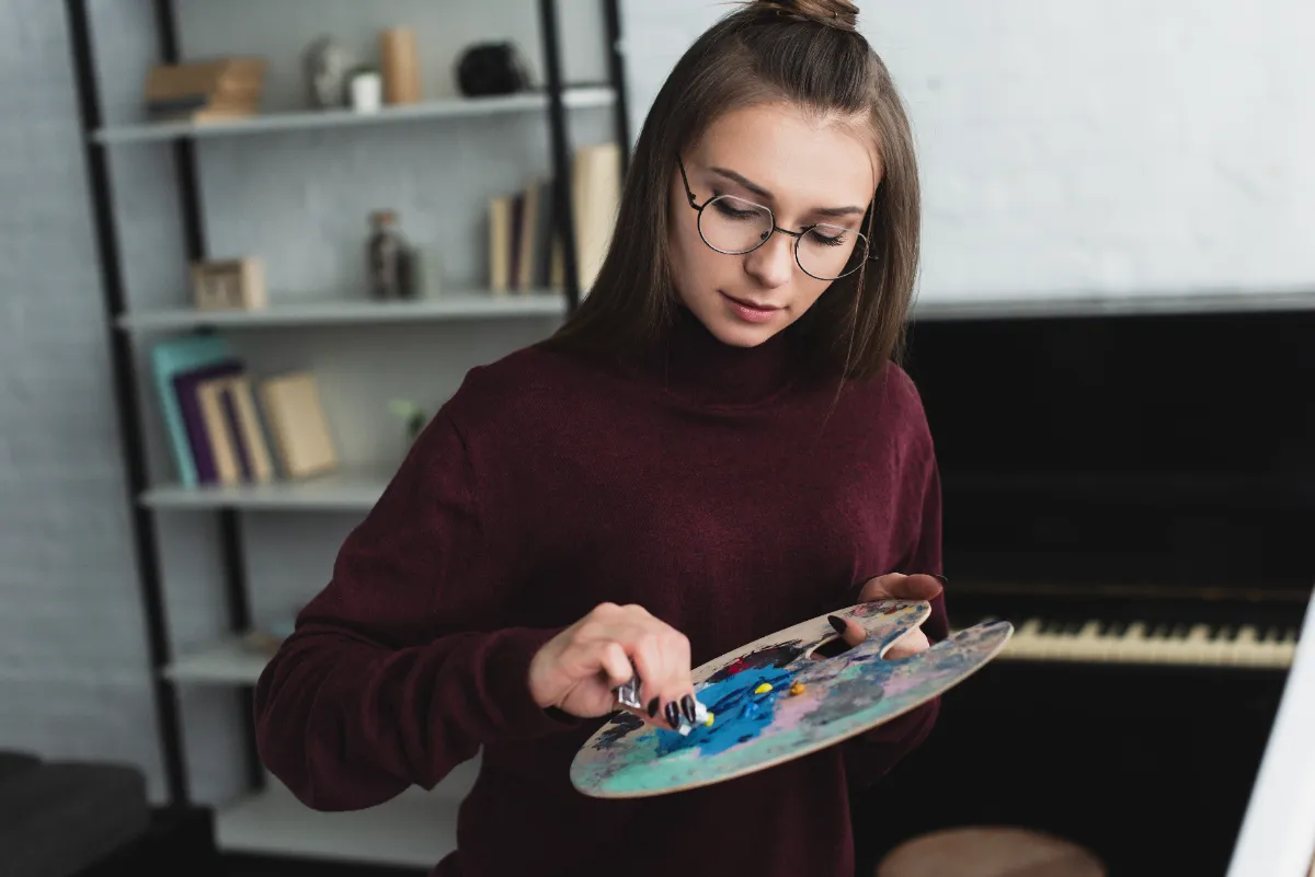 woman in sweater mixing paint